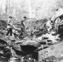 12.Four unidentified boys walk over rocks