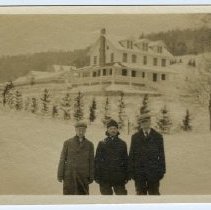 02.10 Pecketts, three men standing in a field with the inn in the backgroun