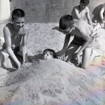 Boy being buried in sand