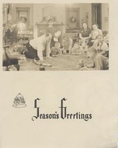 "Seasons Greeting" Card with Family Sitting Around Toy Train on Floor