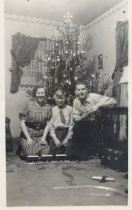 Two Boys and Woman with Toy Trains by Christmas Tree