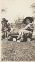 Two Children in Cowboy Outfits, One on Ride-On Locomotive