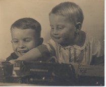 Two Smiling Children Play with Lionel Trains