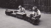 Two Boys Play Outside with Large Toy Train Set