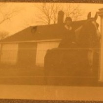 Woman on a horse in front of a barn