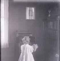 Young girl looking into a cabinet