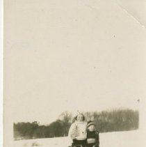 Two children and a dog with a sled