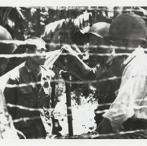 Soldiers talking through fence