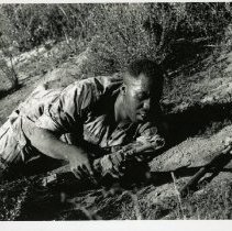 Fort Ord -field maneuvers: soldier crawling with weapon