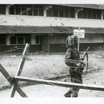 Operation Just Cause - Panama: soldier on patrol in front of damaged building