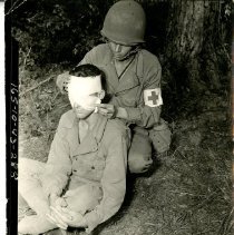 Army Medic Wraps a Soldier's Face in Gauze