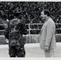 Civilian and Soldier Standing in front of a Crowd of Soldiers