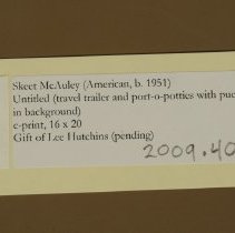 Untitled (travel trailer and port-o-potties with pueblo in background)