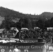 Buster Keaton on tender chopping wood with troops marching in background.