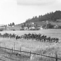 Troops marching through field.