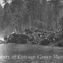 Troops on horseback along riverbank at train wreck site