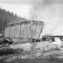 Covered railroad bridge scene with smoke