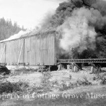 Covered railroad bridge with billowing smoke