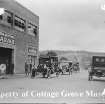 Decorated automobiles next to Woodson Brothers Garage