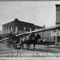 Men in horse drawn wagon with long pole
