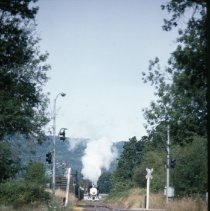 Blue Goose locomotive approaching crossing
