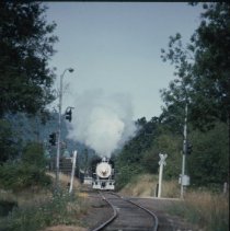 Blue Goose locomotive approaching crossing