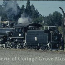 Blue Goose locomotive at water tank near depot