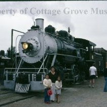 Woman and children posed in front of Blue Goose locomotive