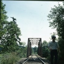 Railroad bridge with man standing trackside