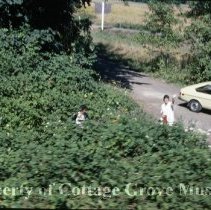 Two women at roadside (picking blackberries)