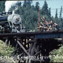 Boys jumping off bridge at Rat Creek with Blue Goose approaching (staged?)