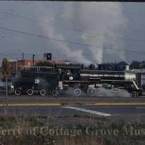 Blue Goose locomotive approaching crossing at 10th and Main Street