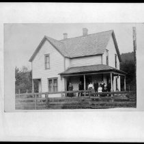 People posed on front porch of house