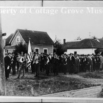 Crowd of men gathered behind marching band
