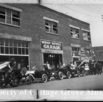 Decorated automobiles next to Woodson Brothers Garage