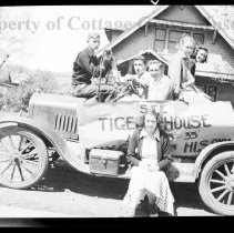 Group of young people posed on car