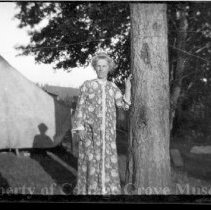 Unidentified woman posed by a tree