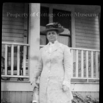 Unidentifed woman posed in front of a porch