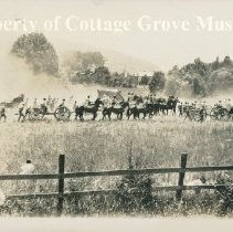 Actors on horseback riding through field