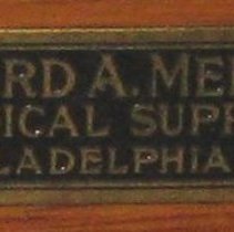 Close up of plaque on back of wheelchair with cane seat and back
