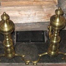 Brass andirons with round brass feet and finial column
