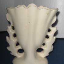 Ceramic vase with fluted top edge and cut out leaf pattern - back view