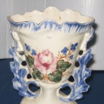 Ceramic vase with fluted top edge and cut out leaf pattern