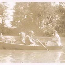 Woman and four children in row boat