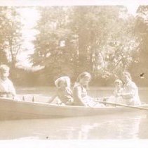 Woman and four children in row boat