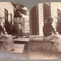 Stereograph of a woman sitting on a step with a dogon her lap