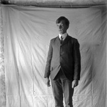 Formal Portrait of Man Standing in front of Drapery