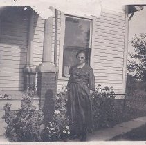 Photograph from Baldwin scrapbook of woman in front of house (ca. 1926)