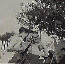 Three women standing next to picket fence (ca. 1910-1920)