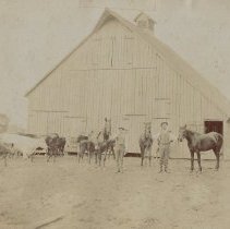 A man & boy in front of barn  (ca. 1890-1910)